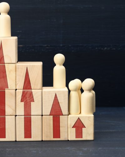 Wooden figures of men on a ladder made of blocks. Concept of career advancement